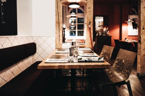 a wooden table in a restaurant with chairs and a tableablish at Achtender in Metzingen