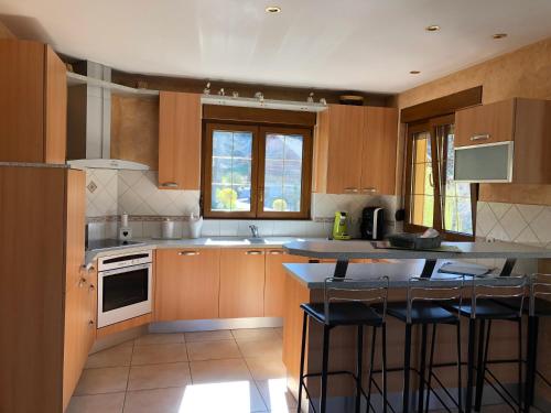 a kitchen with wooden cabinets and a counter with bar stools at Buhl de Bonheur in Guebwiller