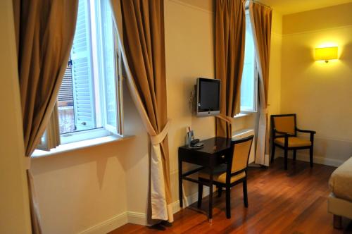 a room with a desk and a tv and a window at Albergo Sant'Emidio in Ascoli Piceno