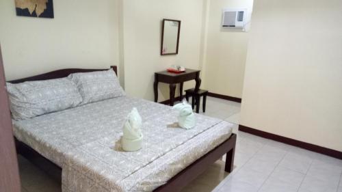 a bedroom with a bed and a table in it at Johann Ritz Place in Dumanjug