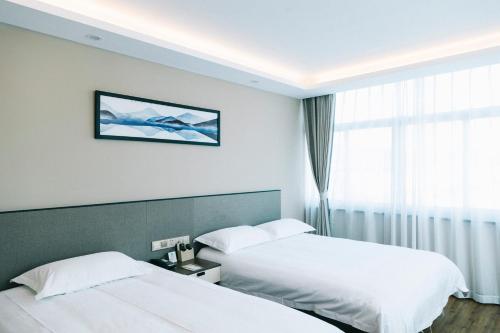 ein Hotelzimmer mit 2 Betten und einem Fenster in der Unterkunft Hangzhou Yuqi Hotel in Hangzhou