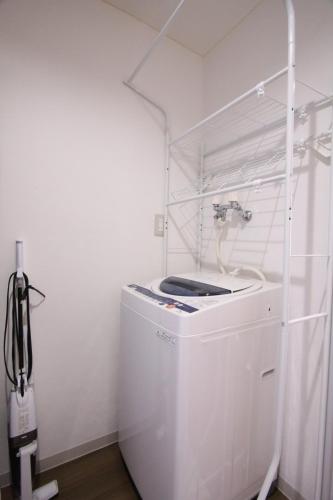 a white laundry room with a washer and a sink at Apartment Susukino Hakuhou Building in Sapporo