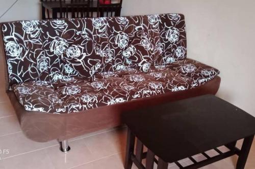 a brown couch with a black and white pattern on it at Desa Impian Tanah Merah Homestay in Tanah Merah
