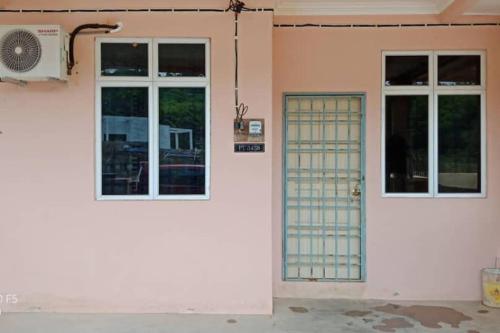 a front door of a house with a fan at Desa Impian Tanah Merah Homestay in Tanah Merah