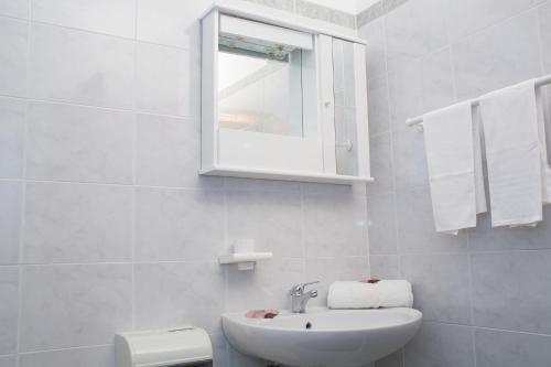 a white bathroom with a sink and a mirror at Albergo Villa Marchese in San Giovanni Rotondo