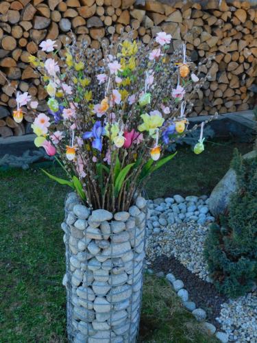 a vase filled with flowers in a pile of rocks at Pod Dubom in Liptovský Mikuláš