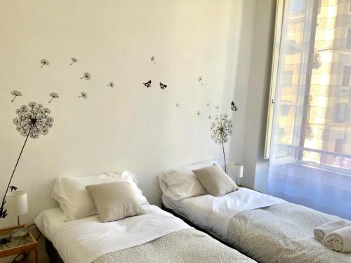 dwa łóżka w pokoju z motylami na ścianie w obiekcie Le Rondini a Roma w Rzymie