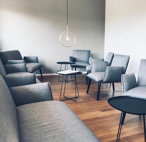 a waiting room with chairs and tables and a light fixture at Weingut Gehlen-Cornelius in Brauneberg