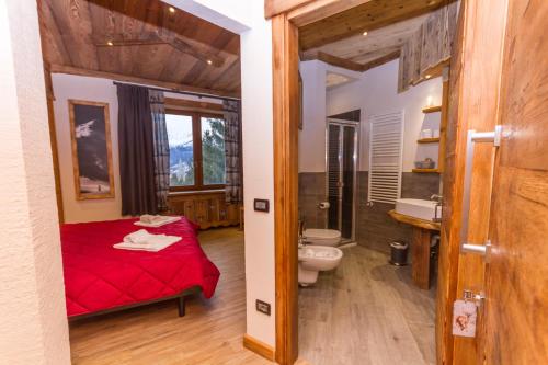 a bathroom with a red bed and a toilet at Hotel Sauze in Sauze dʼOulx