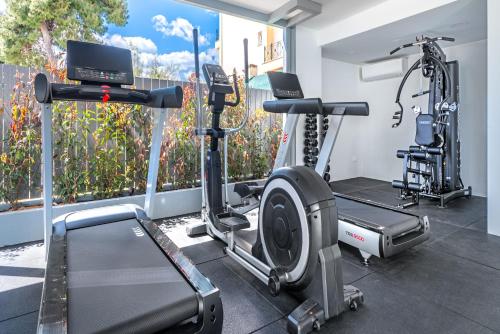 a gym with two tread machines and a treadmill at Glyfada Riviera Hotel in Athens