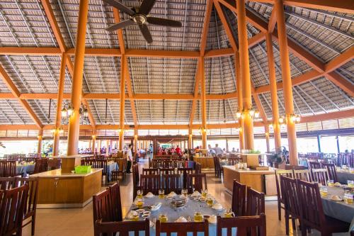 uma sala de jantar com mesas e cadeiras e um tecto em Huong Phong Ho Coc Beach Resort em Ho Coc