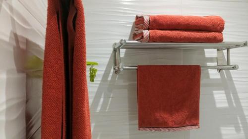 un gruppo di asciugamani rossi su un portasciugamani in bagno di Apartamentos Ferrán Paqui a Roses
