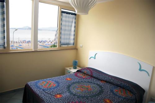 a bedroom with a bed and a view of a beach at Hotel Villa Del Mare in Bacoli