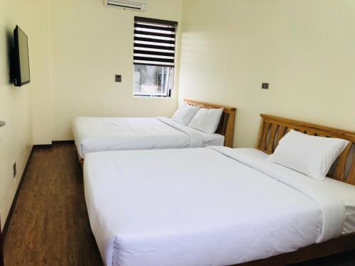 two white beds in a room with a window at Ninh Binh Brother's Homestay in Ninh Binh