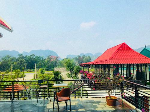 a building with a red roof and a table and chairs at Ninh Binh Brother's Homestay in Ninh Binh