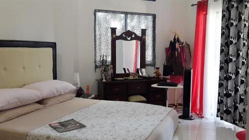 a bedroom with a bed and a dresser and a mirror at Apartamento Residencial Costa Azul in Santo Domingo