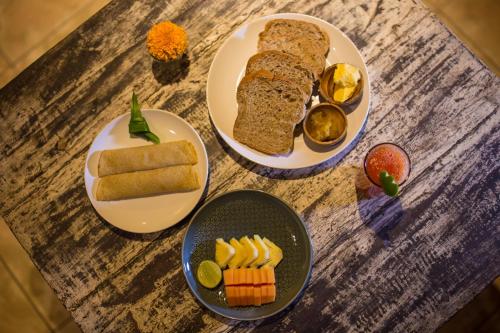 drie borden eten op een houten tafel bij Pondok Permata Homestay in Ubud