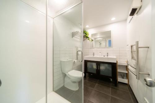 een witte badkamer met een toilet en een wastafel bij Central, Modern Loft Style Home - 2 Min walk from Town in Queenstown