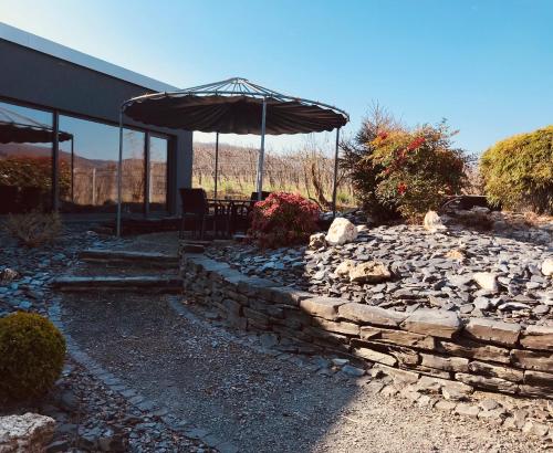 a stone patio with an umbrella and a stone wall at Weingut Gehlen-Cornelius in Brauneberg