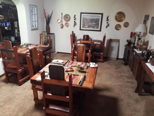 a dining room with wooden tables and chairs at Khokha Moya Guesthouse in Ermelo