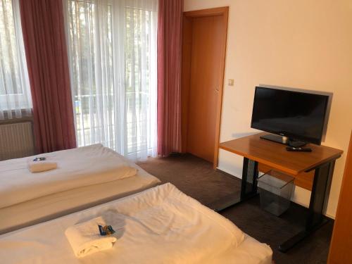 une chambre d'hôtel avec un lit et une télévision dans l'établissement Hotel Mivano Lehrte, à Lehrte