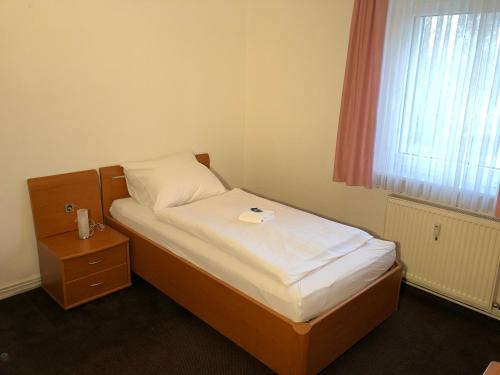 a small bed in a room with a window at Hotel Mivano Lehrte in Lehrte