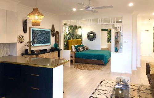 a living room and a bedroom with a bed in it at NOMAD - Luxe apartment in Port Douglas