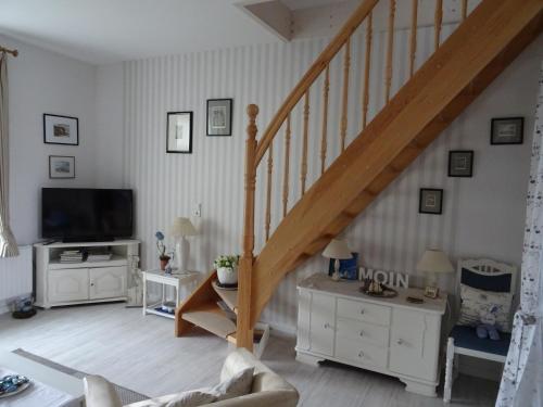 a living room with a staircase and a tv at Stadtwohnung Süderbrarup in Süderbrarup