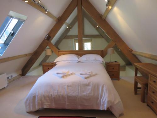 a bedroom with a white bed in the attic at Welsh Apple Barn in Chepstow