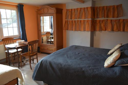 1 dormitorio con 1 cama, mesa y sillas en Julienne5 en Blégny