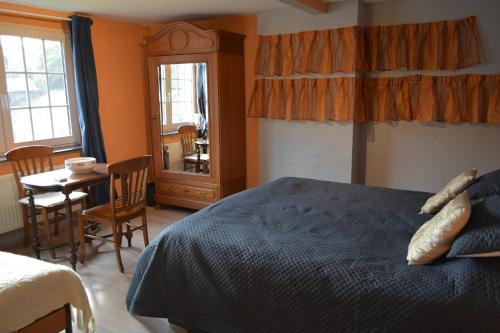 a bedroom with a bed and a table and chairs at Julienne5 in Blégny