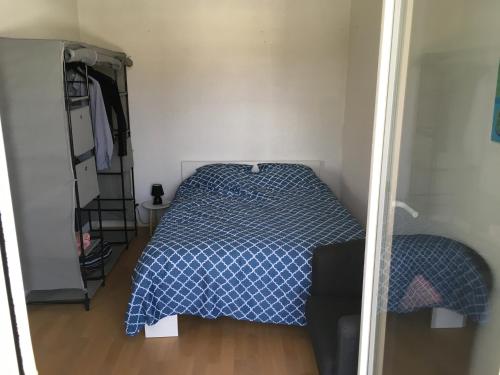 une chambre avec un lit avec une couette bleue dans l'établissement T1 bis Auray, à Auray