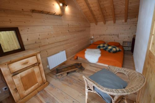 chalet perché في Huez: غرفة صغيرة مع سرير في كابينة خشب