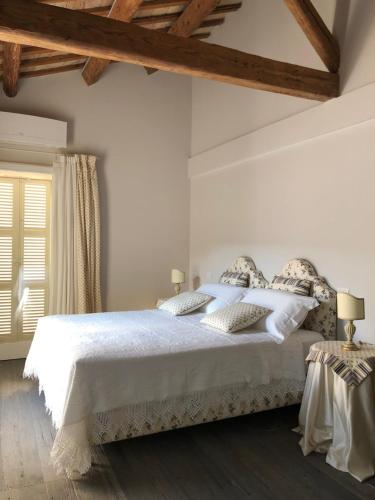 una camera con letto bianco e soffitto in legno di Le Case Cavour a Ravenna