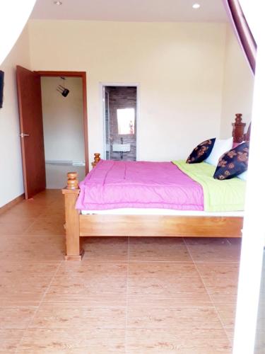 a bedroom with a bed with a purple bedspread at Jakson Homestay in Batam Center