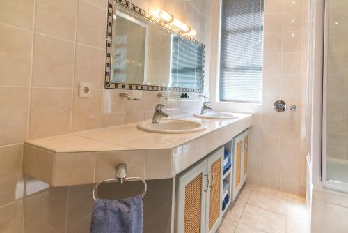 a bathroom with two sinks and a mirror at Chala-Kigi Apartments in Swakopmund