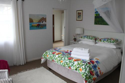 a bedroom with a large white bed with colorful pillows at Hubbs Place in Sedgefield