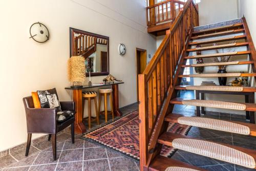 a staircase in a room with a table and a chair at Chala-Kigi Apartments in Swakopmund