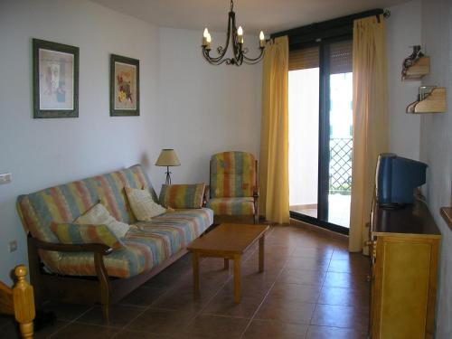sala de estar con sofá, mesa y TV en Alquiler Vacaional Verano en Zahara de Los Atunes, en Zahara de los Atunes