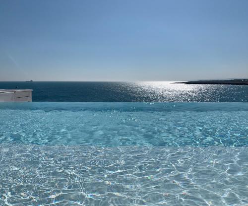 a pool of water with the ocean in the background at Bellavista Suites in Monopoli