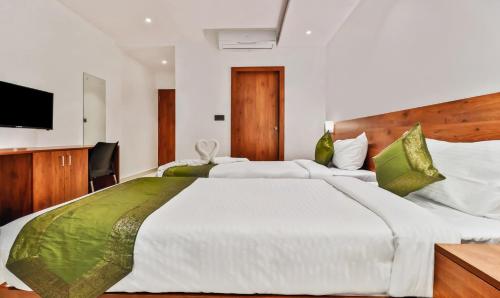 a bedroom with a large bed and a television at Treebo Blu Orchid in Bengaluru
