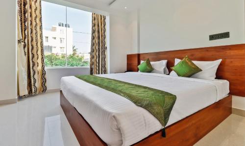 a bedroom with a large bed and a window at Treebo Blu Orchid in Bengaluru