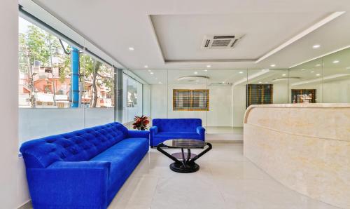 a living room with a blue couch and a table at Treebo Blu Orchid in Bengaluru