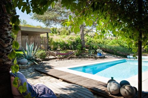 a swimming pool with a hammock in a yard at Chambre d'hôtes Clos du Petit Jésus in Cassis