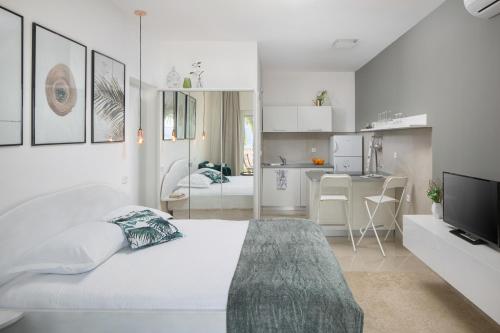 um quarto branco com uma cama grande e uma cozinha em Studio apartment close to the sea em Rabac