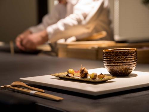 a plate of food and a cup on a table at Maki No Oto Kanazawa in Kanazawa