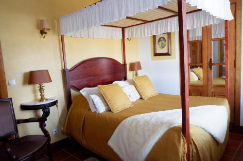 a bedroom with a large bed with a canopy at Quinta da Rica-Fé in Bragança
