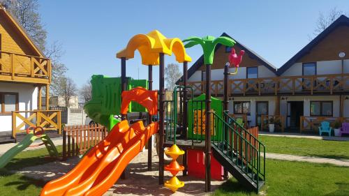 a playground with a slide in a park at Tropikana Domki, Apartamenty in Mielno