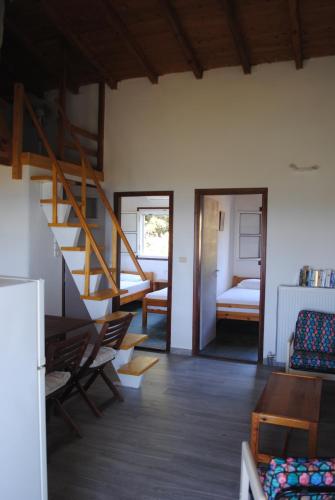 a living room with a staircase and a bedroom at Beaufort apartment in Stoupa