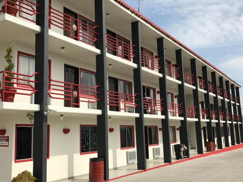 ein Gebäude mit roten Balkonen und Personen auf dem Balkon in der Unterkunft Motel El Refugio in Tijuana